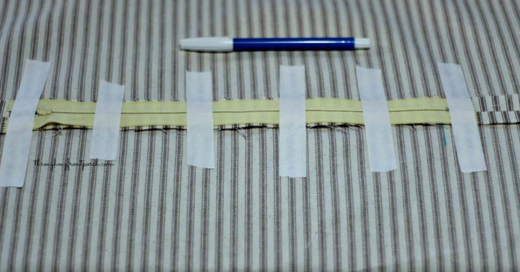 Zipper taped to fabric with marking pen on top.