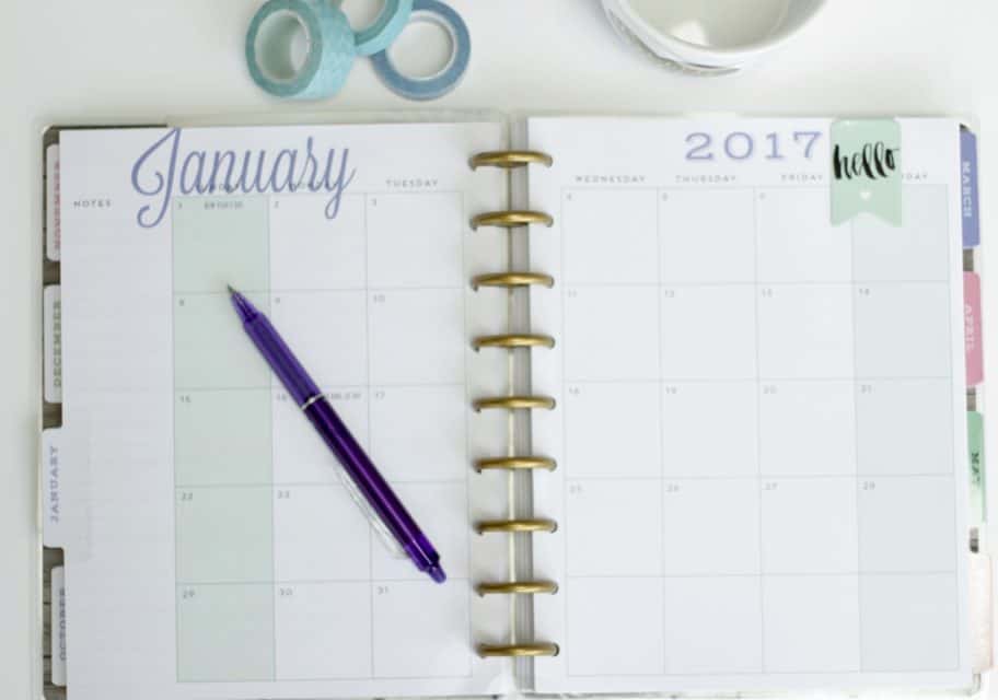 An open planner with a pen and washi tape.