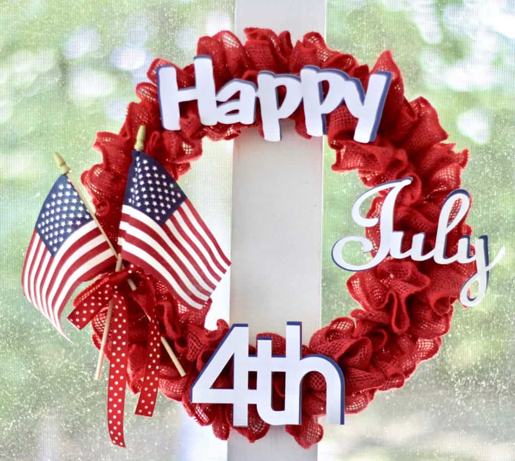 4th Of July burlap ribbon wreath hanging on a post.