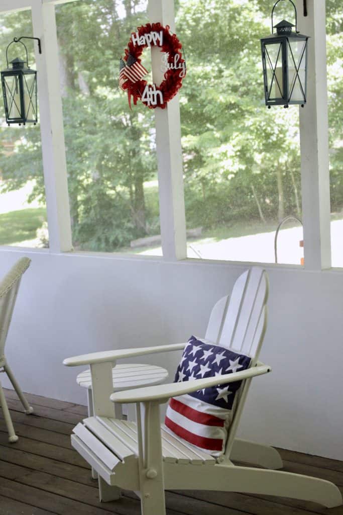 A chair and a wreath in a sunroom.
