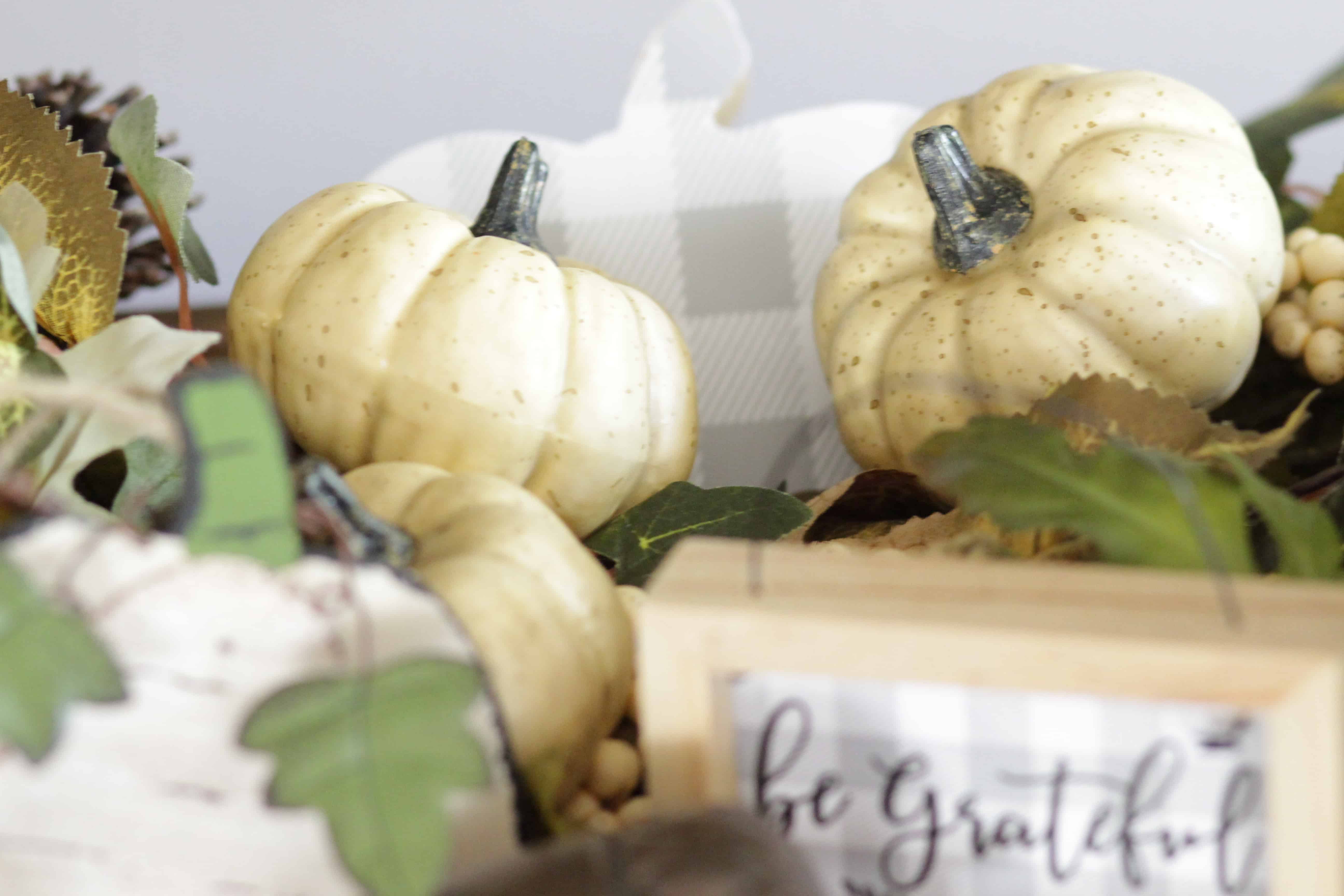 A closeup of pumpkins and a be grateful sign.