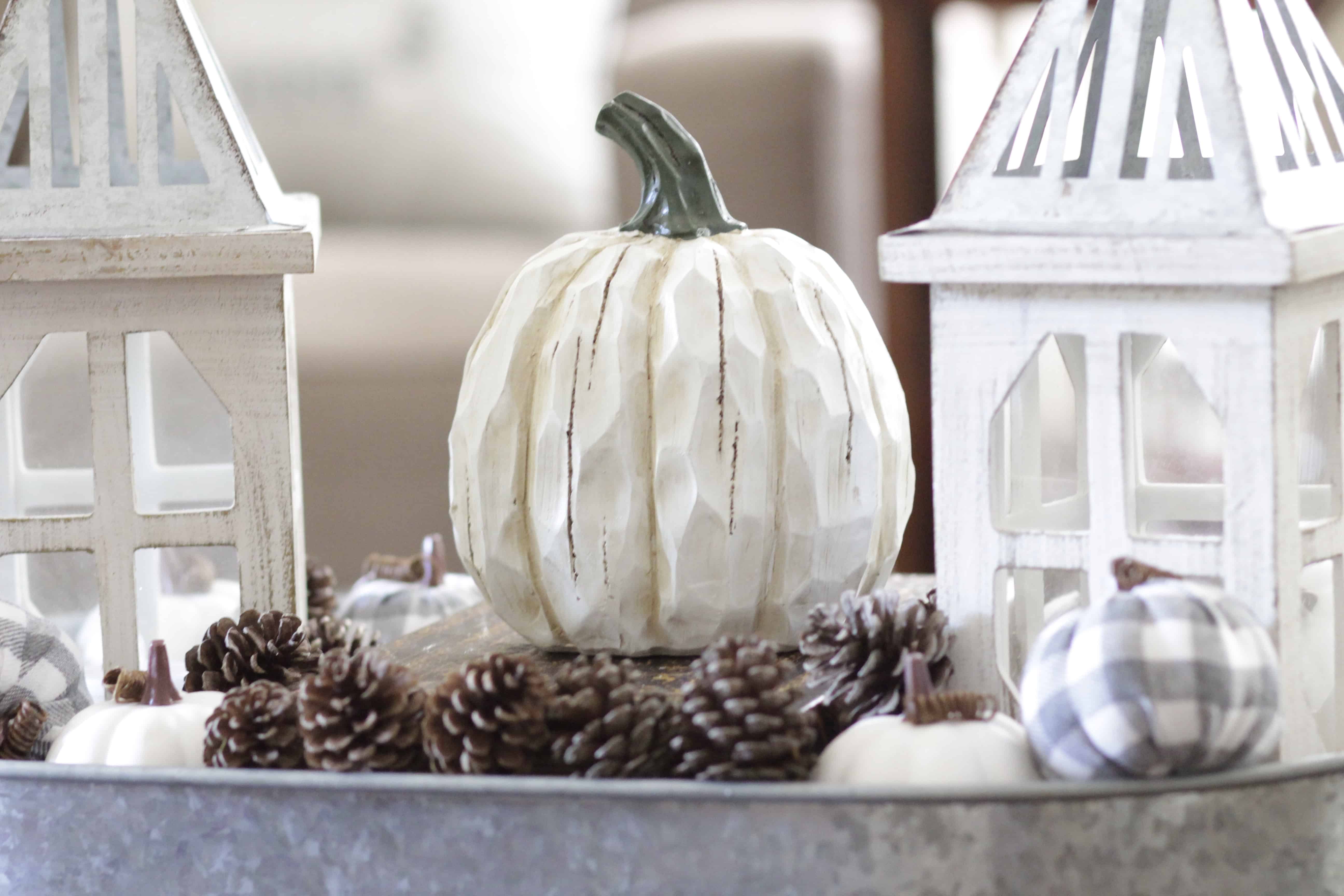 A closeup of a metal tray with lanterns and pumpkins.