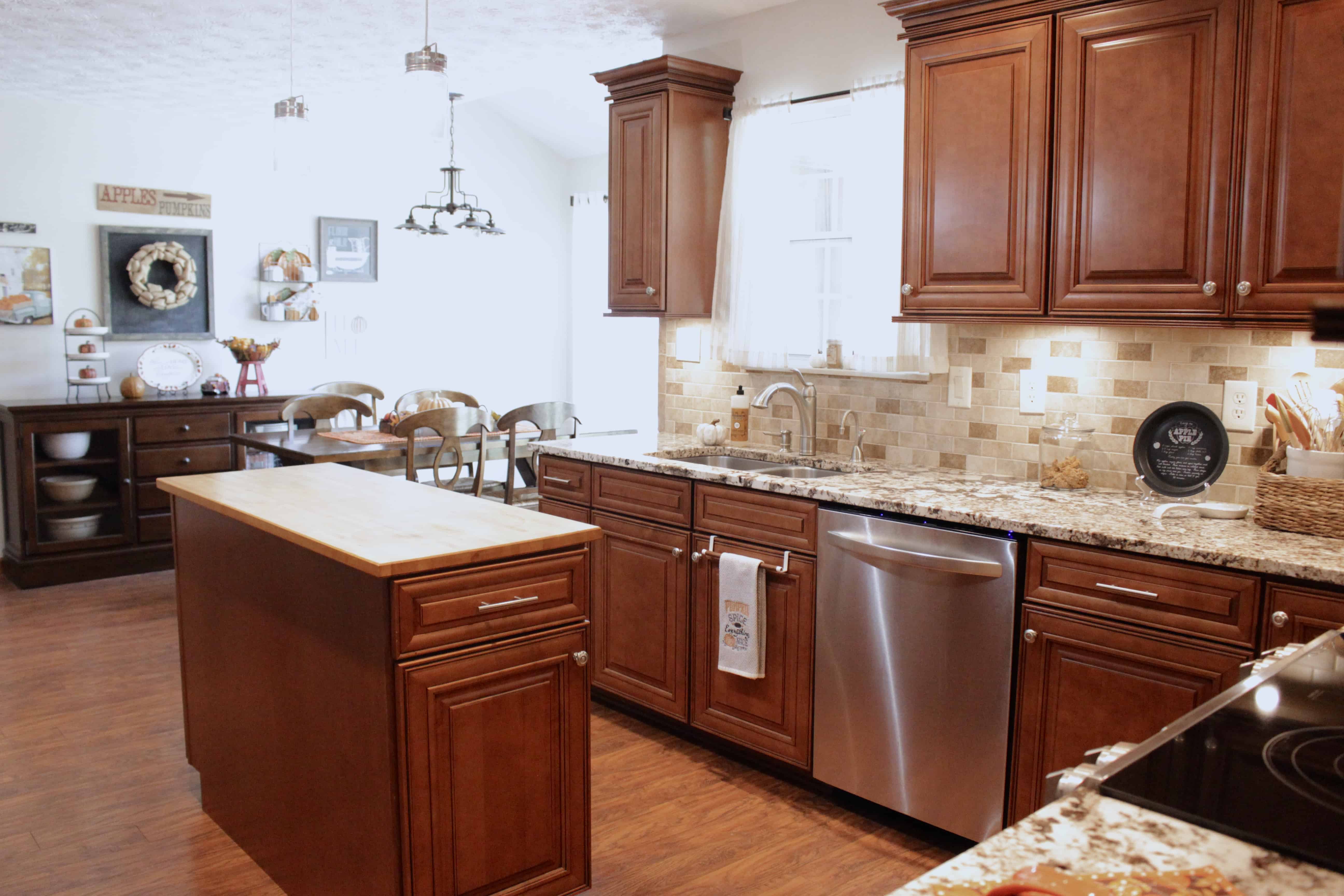 A kitchen decorated for fall with a table and chairs in the background.