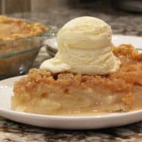 A slice of apple crumble pie on a plate.