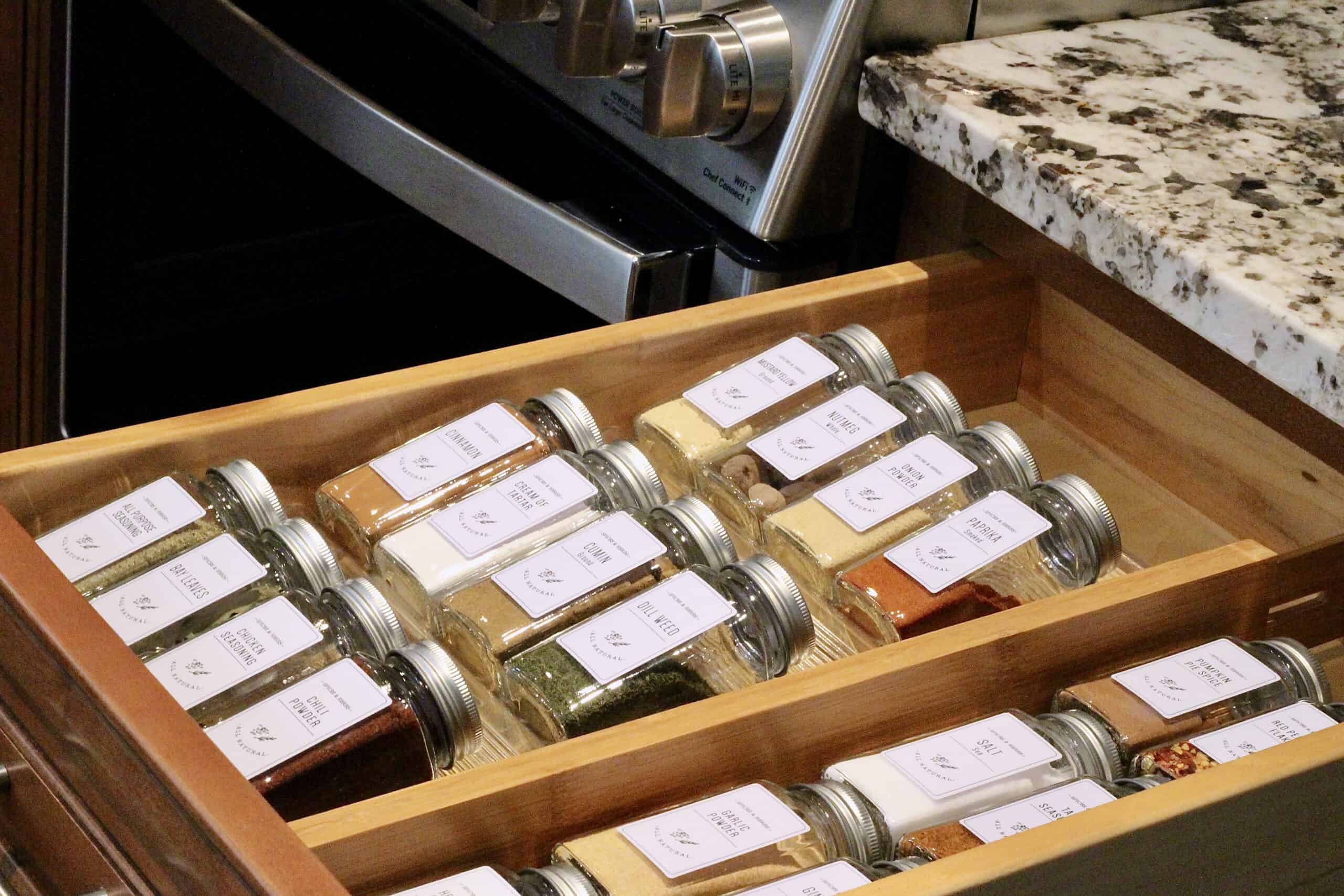 Spice jars laying in a drawer next to the stove.
