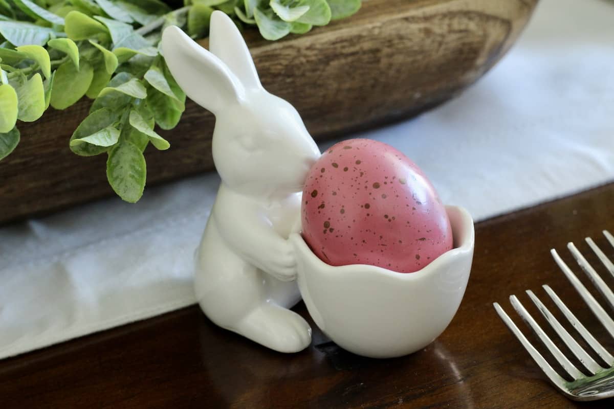 A bunny egg holder with a speckled egg.