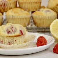 Lemon raspberry muffins with raspberries and a lemon half.