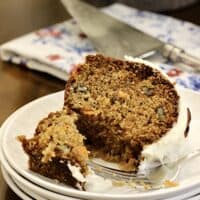 A bite out of a carrot cake slice with a fork.